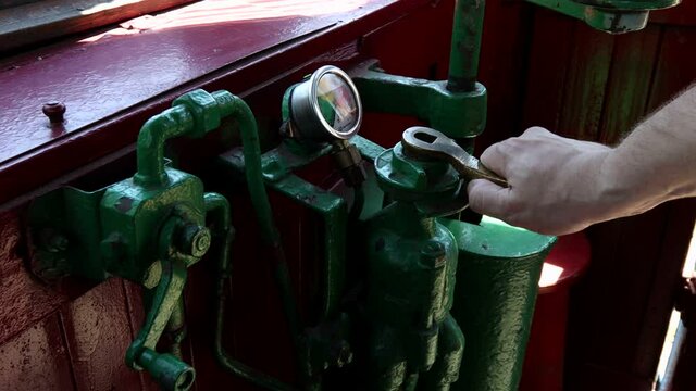 A man turns the control lever of a retro tram.