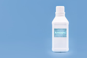 plastic container, bottle written in English: antiseptic, solid blue background with copy space