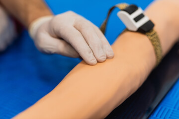 Laboratory with nurse pre-collecting a blood sample from patient - doll. Close up, first aid