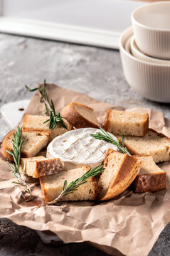 Baked camembert with toasts on rustic background