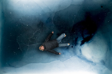 Dark blue ice sheet depicting a frozen arctic ocean surface, with a man laying on the ice smiling happily