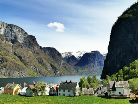 Village houses on the shore of a lake and mountains in the background in Undredal, Norway