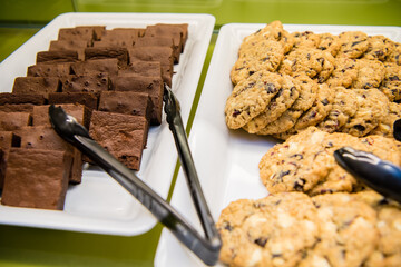 Brownies and oatmeal raisin cookies on a white try