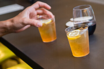 Hand holding fresh cold draught sour beer with lemon