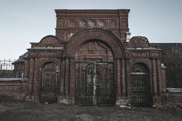 An old beautiful and scary abandoned church. Brick walls. Gloomy gothic atmosphere. Evening light.