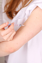 close-up on vaccine and injection and hand against covid19