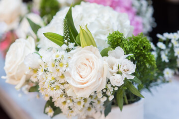 Bouquet of white roses with blurred background and green accents