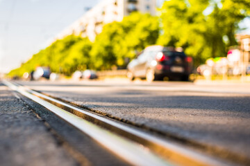 Sunny day in a city, view of the flow of cars approaching from the level of the tram rails