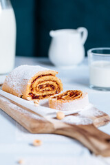 Strudel served on a wooden board and glass of milk