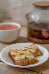 Homemade peanut butter  sandwich with bananas on wooden background