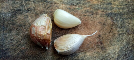 the garlic lies on a wooden table. Garlic on vintage wood background.