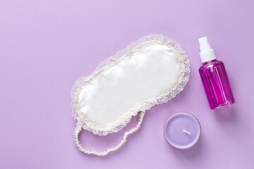 Eye mask for sleeping, lavender candle, lavender oil on a pink background. The concept of restful sleep. Space for text