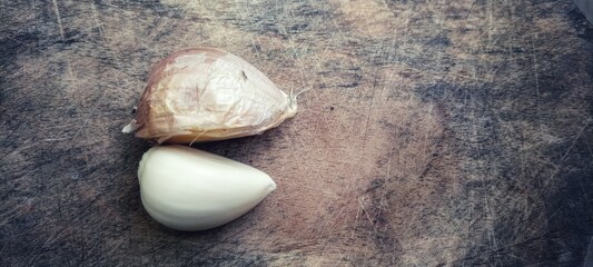 the garlic lies on a wooden table. Garlic on vintage wood background.