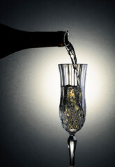 Sparkling wine is poured from a bottle into a glass.