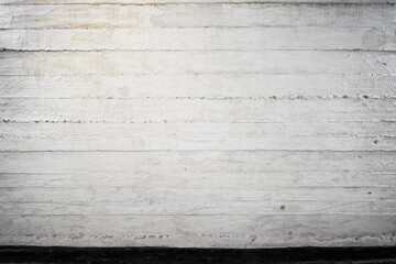 Old concrete wall with visible layers, painted white and black, fragment