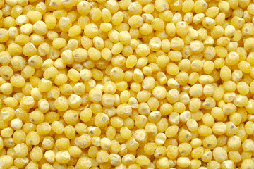 Millet yellow grains, background, top view. Processed millet grains, texture, macro, close-up. Peeled yellow millet grains, top view, background. Yellow grains of millet.