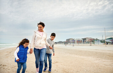 Happy mother with her children walking on the beach. Happy family concept. Happy motherhood concept. Happy mother's Day