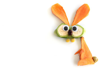 Food art creative concepts. Funny bunny rabbit made of fruits and vegetables, such as carrots and cucumber isolated on a white background.