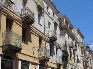 Fototapeta na wymiar Sardinian Street View with Building Facades and Iron Balconies in Nuoro, Italy
