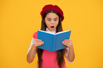 surprised teen school girl in french beret reading book on yellow background, surprise