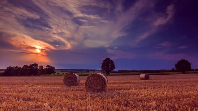 4k time lapse with straw bales on field under nice sky.