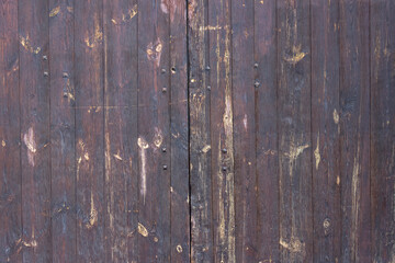 The surface of an old wooden wall made of boards darkened by time and weather. Traditional Russian...