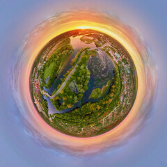Spherical 360 degrees panorama of sunrise over landscape with fields and green grass. Little planet...