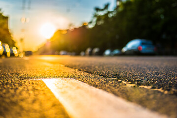 Sunny day in a city, view of the road at the level of the dividing line