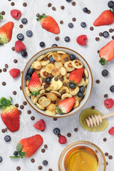 Pancake cereal flat lay with fruit, honey and chocolate chips 