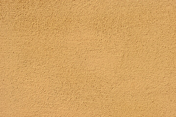 Plaster on a yellow wall. Concrete wall texture close up.