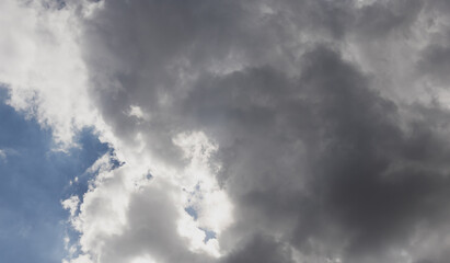 Gray rain clouds cover the blue sky