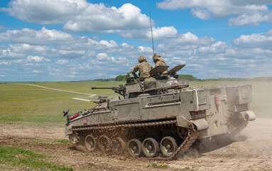 british army FV510 Warrior light infantry fighting vehicle tank in action on a military battle...