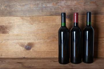 bottle with red wine on wooden background