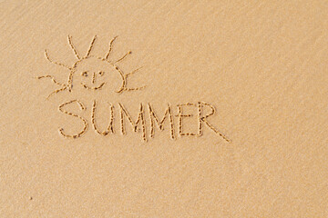 Drawing of the sun on the sea sand. Happy vacation concept