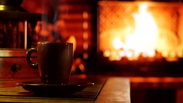 A burning fireplace with a cup of steaming coffee. Cozy home mood.	