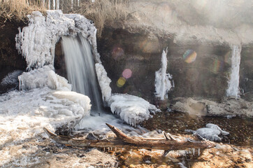 Beautiful waterfall by the sea in sunny winter day, Staldzene, Latvia.