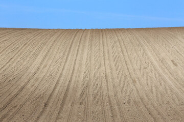 Naklejka premium Landscape agricultural land in slope recently plowed for the crop