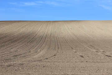 Naklejka premium Landscape agricultural land in slope recently plowed for the crop