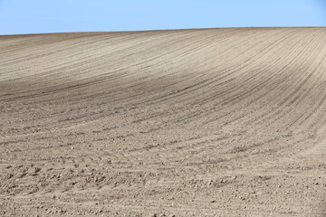 Fototapeta premium Landscape agricultural land in slope recently plowed for the crop