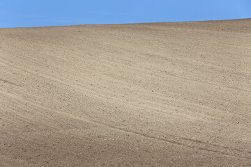 Landscape agricultural land in slope recently plowed for the crop