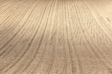 Plowed cultivated agricultural land field at springtime rural landscape as a background