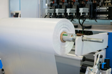 Moving roller with flat polyethylene transparent film - automatic plastic bag making machine at...
