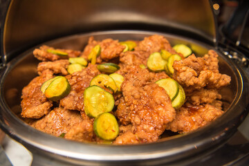 Fried chicken strips with pickles in a large serving bowl. Top view