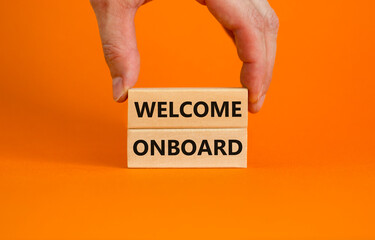 Welcome onboard symbol. Wooden blocks with words 'Welcome onboard' on beautiful orange background....