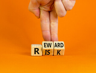Risk or reward symbol. Businessman turns wooden cubes and changes the word 'risk' to 'reward'. Beautiful orange background. Risk or reward and business concept. Copy space.
