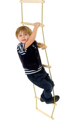 Cute little boy climbing rope ladder