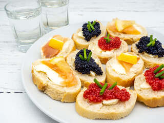 assorted fish roe appetizers with glasses of vodka aside