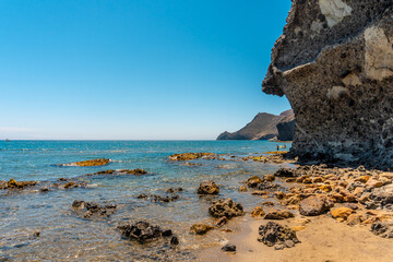 Monsul beach in Cabo de Gata Natural Park, eroded lava formations that surround it, fine sand and crystal clear water. San Jose, Almeria. Spain - obrazy, fototapety, plakaty