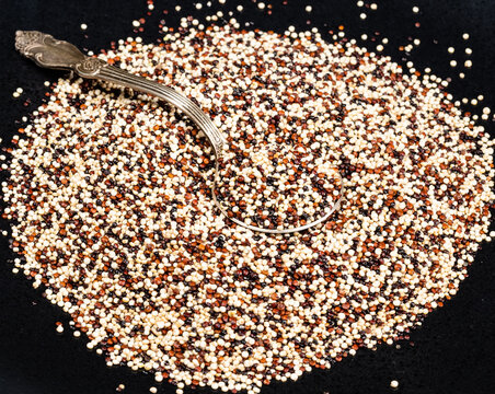 tablespoon in mix of quinoa seeds on black