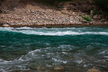 Naklejka premium Fast river with rapids high in the mountains